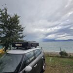 Image of a car with a rooftent next to a lake
